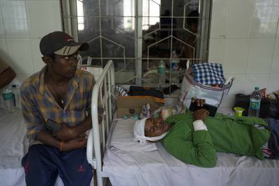 An injured passenger, right, lies in a hospital bed in Balasore, Orissa. AP