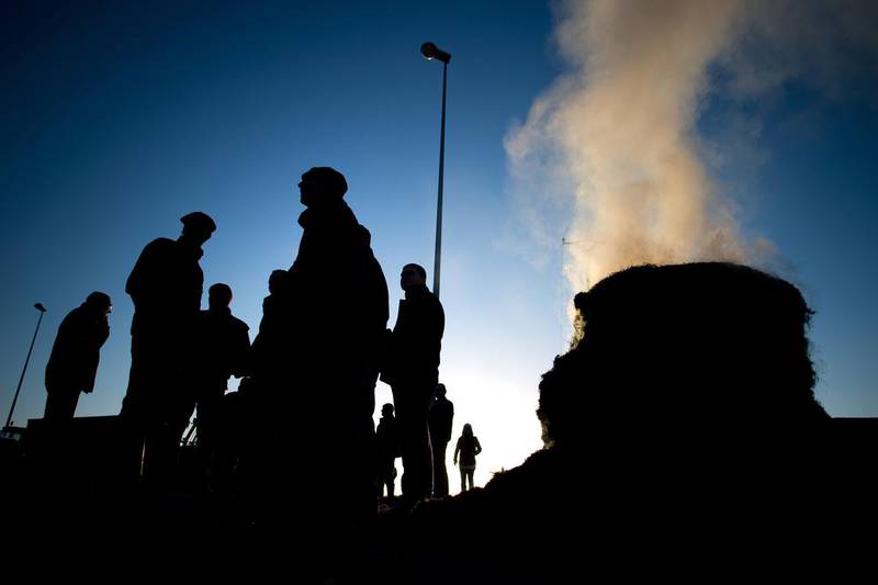 Farmers stand near a fire on the RN 165 motorway to block the road access to Vannes, western France, during a protest against the falling prices of dairy and meat products. Jean-Sebastien Evrard / AFP