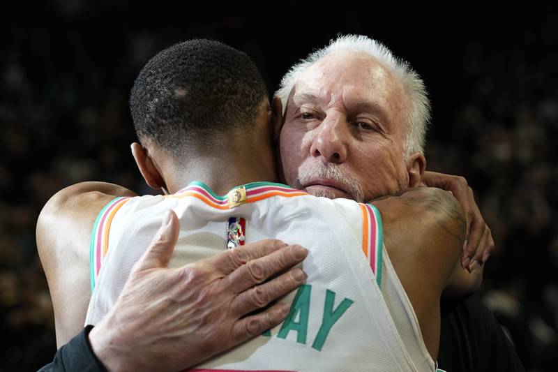 San Antonio Spurs coach Gregg Popovich, right, is hugged by guard Dejounte Murray the team's 104-102 victory over the Utah Jazz. AP Photo