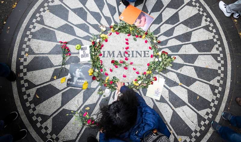A woman lays flowers at the Strawberry Fields memorial to John Lennon in Central Park, New York. EPA