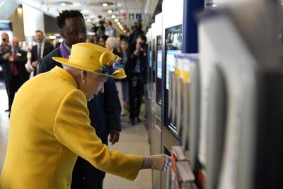 Queen Elizabeth using a oyster card machine at Paddington station. PA