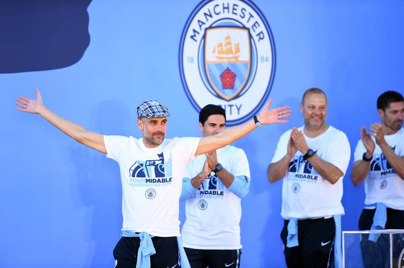 Pep Guardiola, manager of Manchester City, celebrates on stage. Getty Images