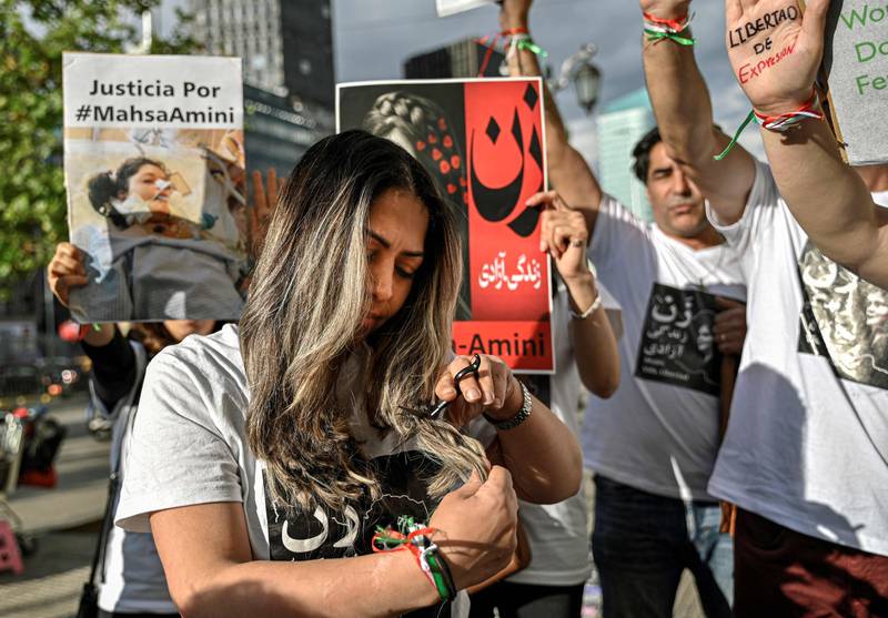 A woman cuts her hair during a demonstration in Santiago, Chile, by feminist groups and Iranian migrants in support of Iranian women following the death of Amini. AFP