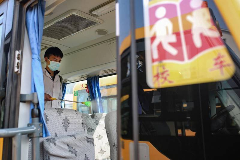 A worker sprays disinfectant inside a school bus in Yongchuan, in central China's Hunan province. AFP