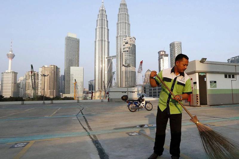 8th: Kuala Lumpur. A worker sweeps a car park in front of the Petronas Towers in Kuala Lumpur. Olivia Harris / Reuters