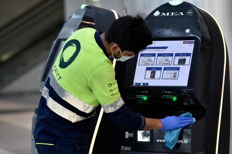 A worker disinfects self check-in counters of the Middle East Airlines at the departure hall of Rafik Hariri international airport in Beirut, Lebanon. EPA