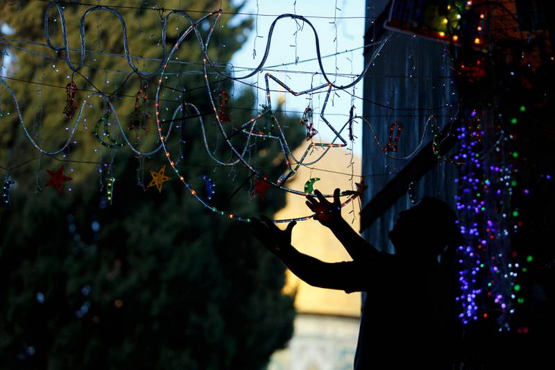A Palestinian man hangs decorations at the entrance to the compound of The Dome of the Rock in Jerusalem's Old City July 8, 2013, ahead of the upcoming holy month of Ramadan. REUTERS/Ammar Awad (JERUSALEM - Tags: RELIGION) *** Local Caption ***  NIR01_ISRAEL-_0708_11.JPG