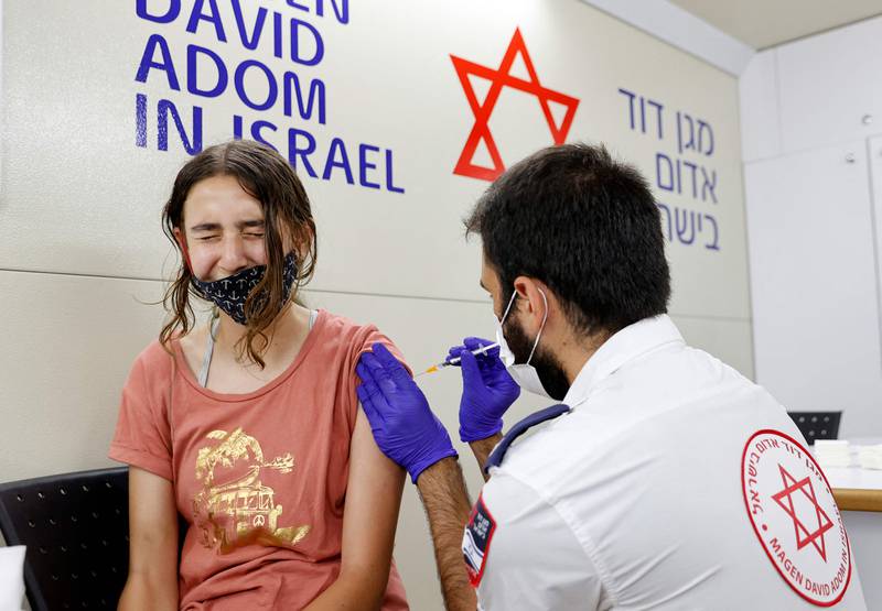 An Israeli girl receives a dose of the Pfizer/BioNTech Covid-19 vaccine from the Magen David Adom during a campaign by the Tel Aviv-Yafo Municipality to encourage the vaccination of teenagers, on July 5, 2021, in Tel Aviv.  - Israel is now urging more 12- to 15-year-olds to be vaccinated, citing new outbreaks attributed to the more infectious Delta variant.  (Photo by JACK GUEZ  /  AFP)