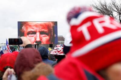 Before the insurrection, Mr Trump is seen on a screen speaking to supporters during a rally to contest the certification of the 2020 US presidential election results. Reuters
