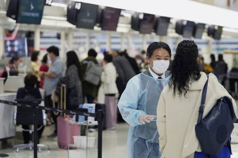 An airline worker helps a passenger at Japan's Narita International Airport, Tokyo. AP Photo