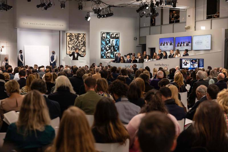 Sotheby's auctioneer Oliver Barker leads an auction of The Macklowe Collection, alongside Andy Warhol's 'Sixteen Jackies', centre, at Sotheby's on November 15, 2021 in New York City.  AFP
