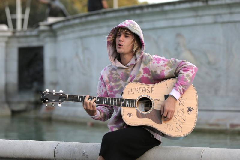 LONDON, ENGLAND - SEPTEMBER 18:  Justin Bieber stops at the Buckingham Palace fountain to play a couple of songs with his guitar for Hailey Baldwin and fans on September 18, 2018 in London, England.  (Photo by Ricky Vigil/GC Images/Getty Images)