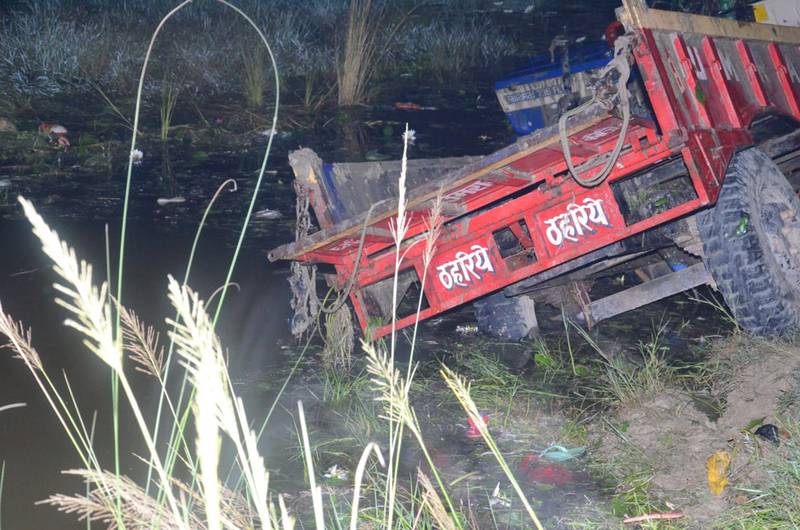 A farm tractor and trailer in a pond in the north Indian state of Uttar Pradesh, where 27 people were killed when the vehicle overturned and fell into the pond. AP