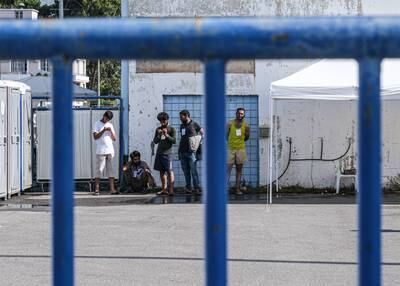 Some of the surviving migrants outside the hangar where they are being temporarily housed. Getty Images