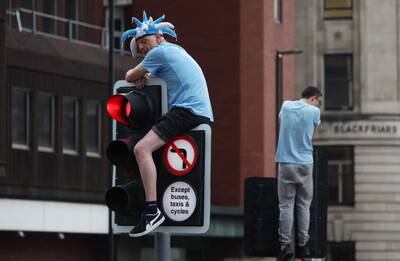 A City fan climbs a traffic light to get a better view. Reuters