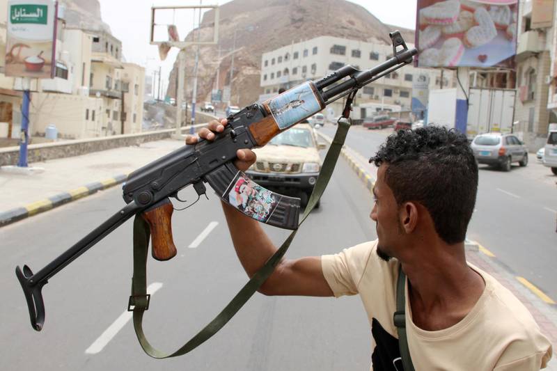 A member of Yemen's southern separatist holds his weapon with a picture of Muneer al-Yafee during a funeral of Brigadier General Muneer al-Yafee and his comrades killed in a Houthi missile attack, in Aden, Yemen, August 7, 2019. REUTERS/Fawaz Salman     TPX IMAGES OF THE DAY