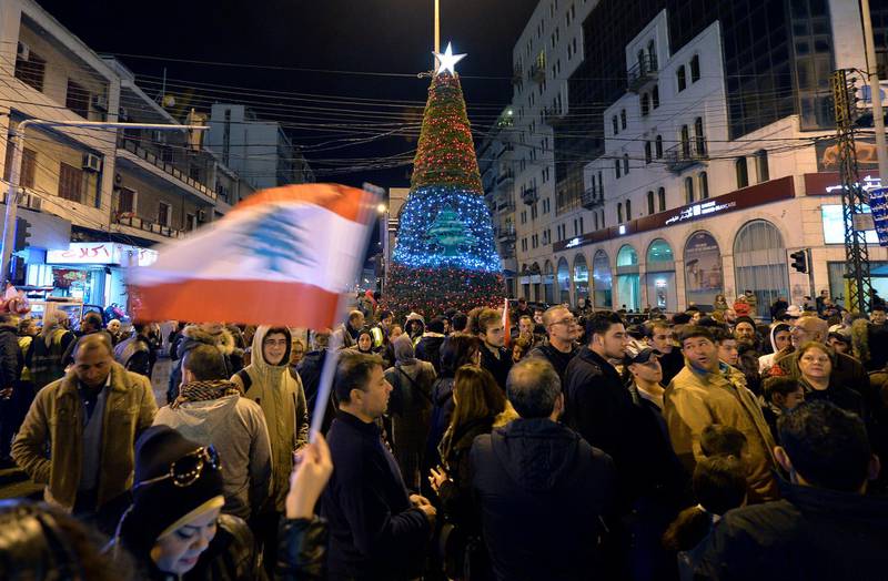 Lebanese people gather next to a Christmas tree which has been officially lit up at the Al Nour Square in Tripoli, northern Lebanon.  EPA