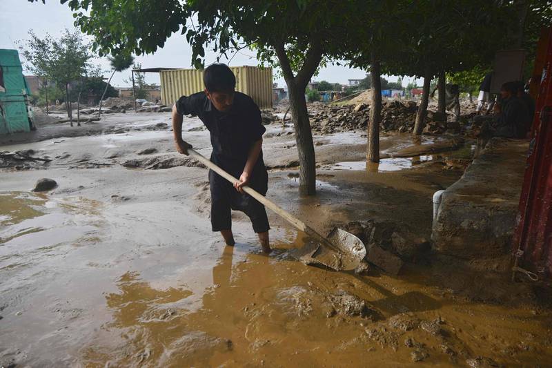 A villager uses a shovel to clear the mud after heavy rains at Charikar in Parwan province. AFP