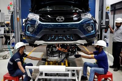 Workers install an electric motor inside a Tata Nexon electric SUV at a Tata Motors plant in Pune. Reuters