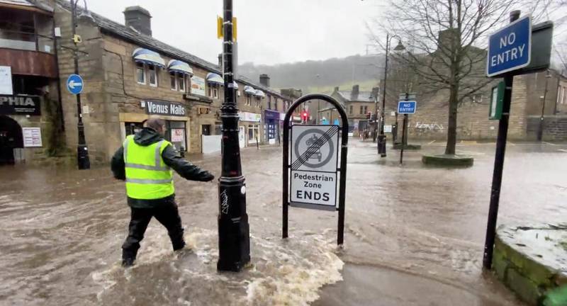 A man wades through a flooded street due to Storm Ciara in Hebden Bridge, West Yorkshire, Britain. REUTERS