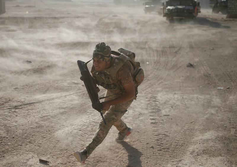 A member of the Iraqi special forces runs for cover. Reuters