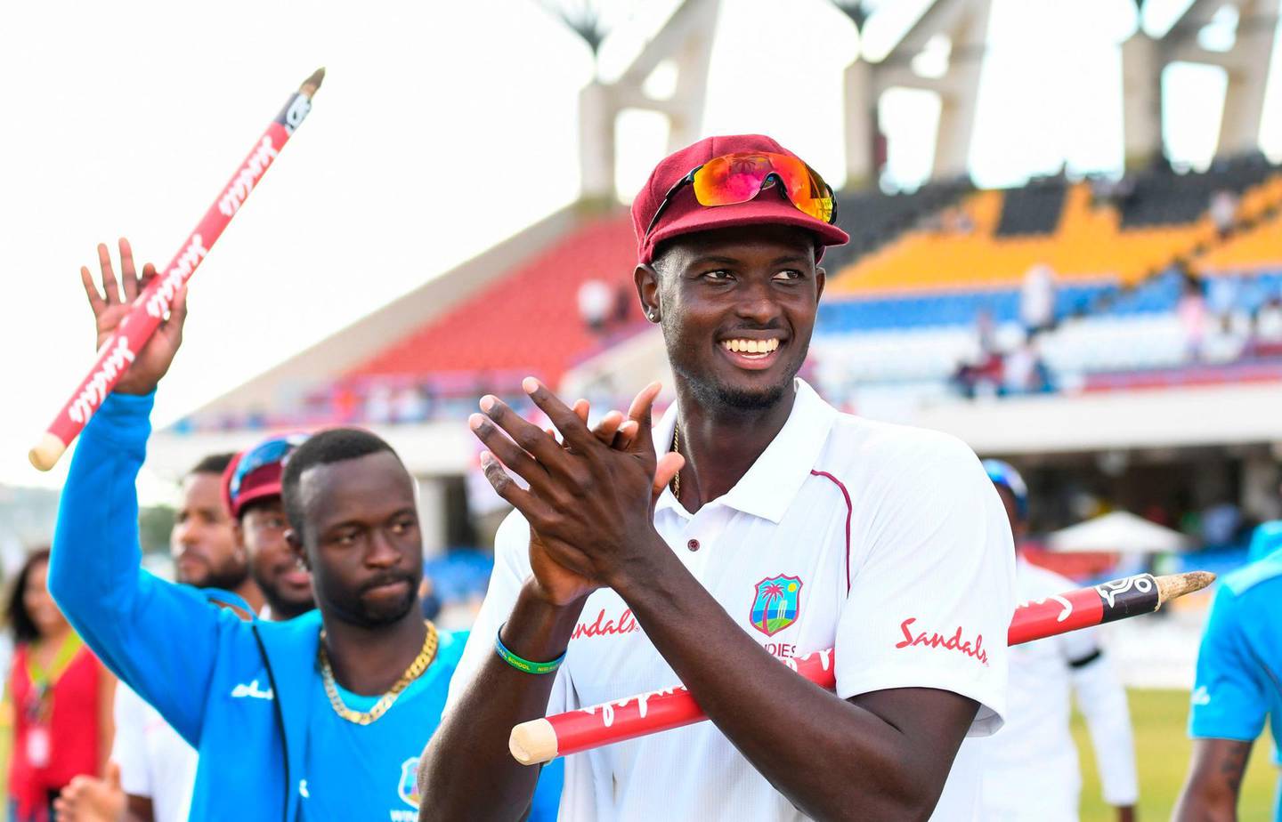 (FILES) In this file photo taken on February 2, 2019 Jason Holder (R) of West Indies celebrates winning on day 3 of the 2nd Test between West Indies and England at Vivian Richards Cricket Stadium in North Sound, Antigua and Barbuda. West Indies captain Jason Holder has been suspended for the third and final Test against England due to his team's slow over-rate during their victory in Antigua last week, the ICC announced on February 4, 2019. Cricket's governing body banned Holder, despite the hosts playing four seamers and the regular fall of wickets as England were bowled out for 187 and 132.The ICC said in a statement that the Windies were two overs short of their target for the match.
 / AFP / Randy Brooks
