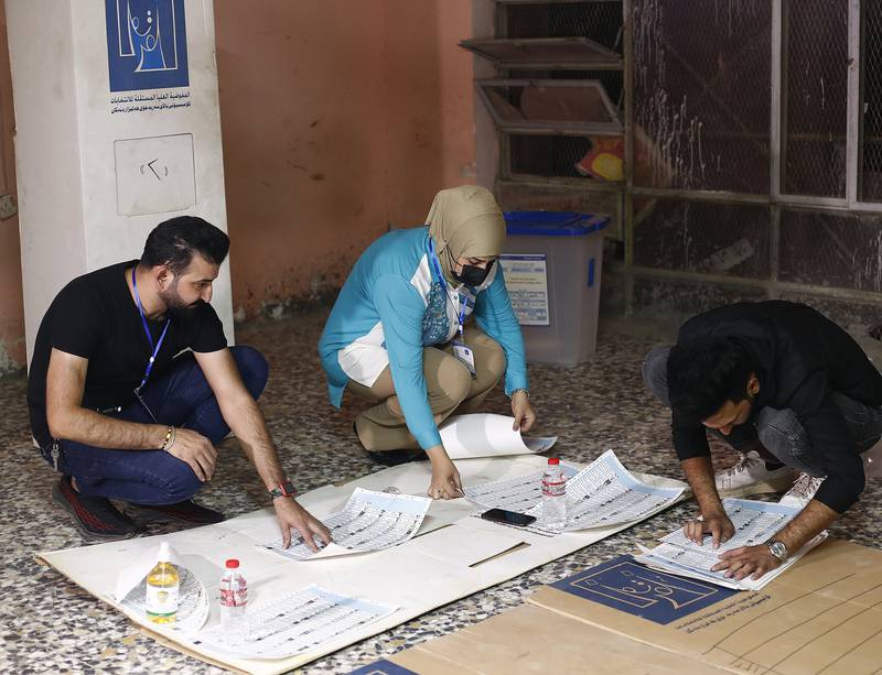 Election workers count ballots at a polling station in Baghdad at the end of voting in parliamentary elections. AP