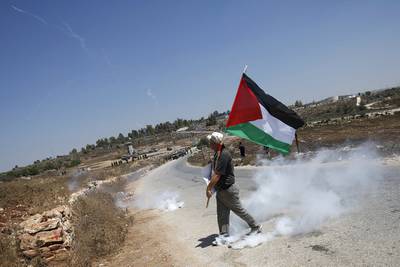 A protester holds a Palestinian flag in the West Bank village of Nabi Saleh. Reuters
