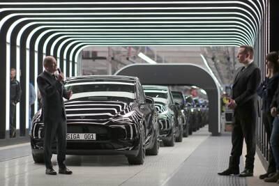 The Tesla chief, right, was cheered as he oversaw the handover of the car maker's first German-made cars at the Gruenheide plant.   EPA