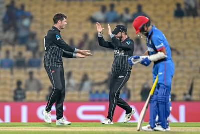 New Zealand's Mitchell Santner, left, celebrates after taking the wicket of Afghanistan's Fazalhaq Farooqi. AFP
