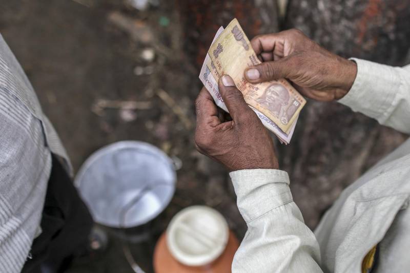 A man counts Indian rupee banknotes during a cattle fair at the Agricultural Produce Market Committee (APMC) wholesale market in Dhule district, Maharashtra, India, on Tuesday, Oct. 10, 2017. The victory of Prime Minister Narendra Modi's Hindu nationalist Bharatiya Janata Party in 2014 national elections has emboldened groups seeking to protect cows, which are considered sacred by many in India's Hindu majority. Since then, attacks on cattle traders have multiplied. Although India's Supreme Court blocked a ban on the sale of cattle destined for slaughter at animal markets across the country from taking effect, some cow-protection groups sought to enforce it anyway. Photographer: Dhiraj Singh/Bloomberg