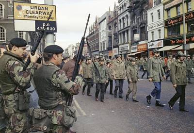 British troops look on as members of the Ulster Defence Association march through Belfast in 1972. AP