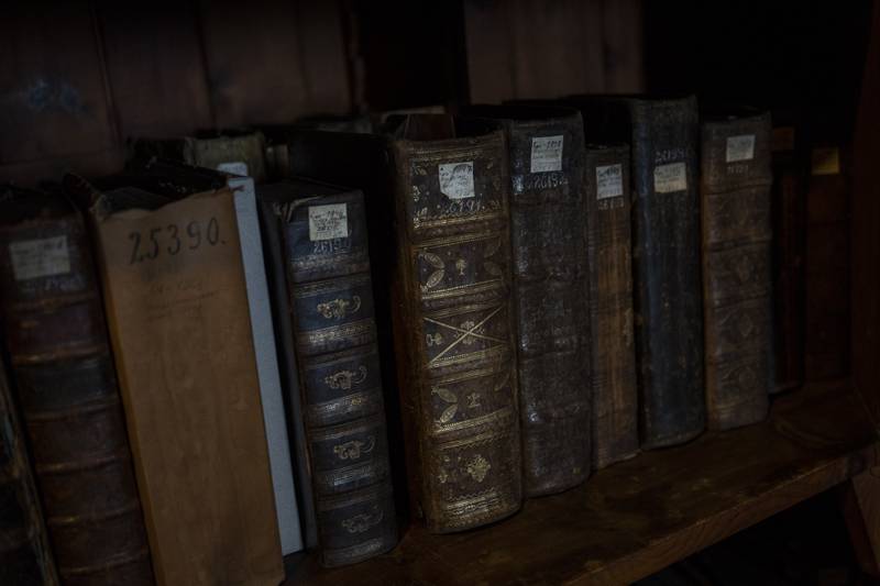 Old books rest on shelves.