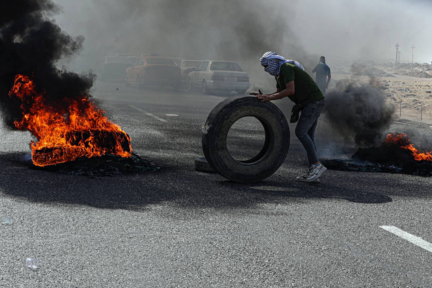 A protester burns tyres during a rally in Basra in June. AP

