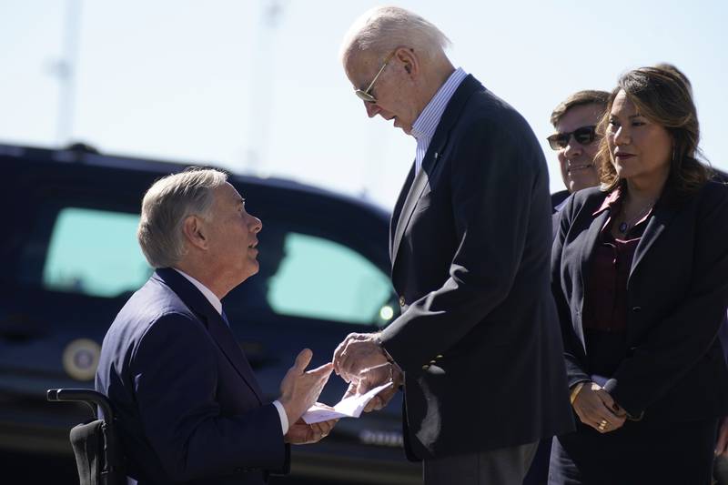 Texas Governor Greg Abbott hands Mr Biden a letter that outlined laws that the governor said would make a great difference, if enforced, in addressing the 'chaos' at the border. AP