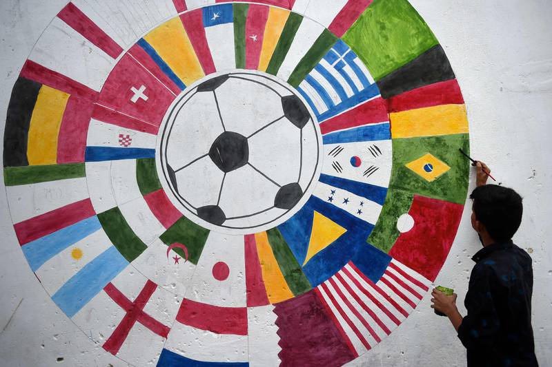 A Pakistani football fan in Karachi paints a mural of countries taking part in the Qatar World Cup finals. AFP