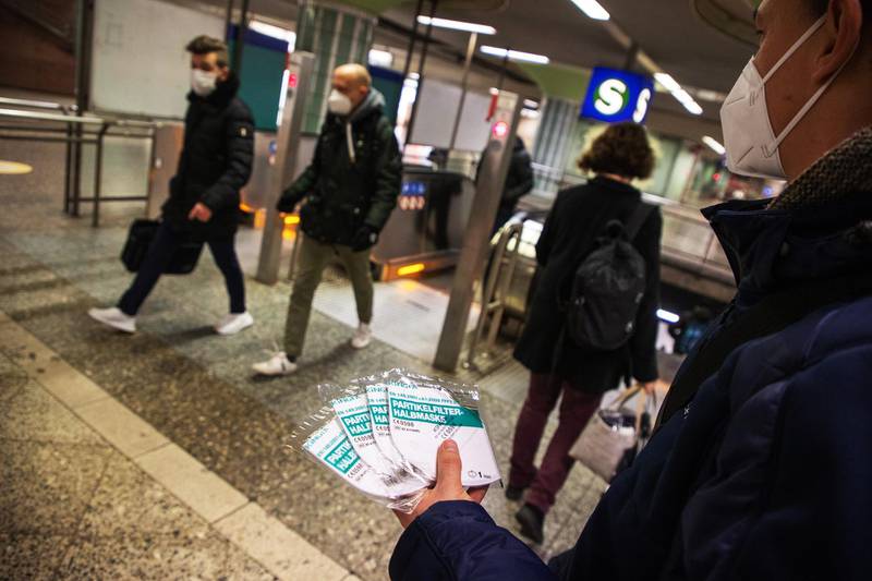 A public transport worker distributes free FFP2 protective face masks to commuters at Frankfurt's central railway station in Germany. Bloomberg