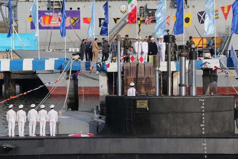 In this photo released by official website of the office of the Iranian Presidency, President Hassan Rouhani, center with white turban, and other dignitaries attend the inauguration of Fateh, "Conqueror" in Persian, Iranian made semi-heavy submarine in the southern port of Bandar Abbas, Iran, Sunday, Feb. 17, 2019. The Fateh has subsurface-to-surface missiles with a range of about 2,000 kilometers (1,250 miles), capable of reaching Israel and U.S. military bases in the region. (Iranian Presidency Office via AP)