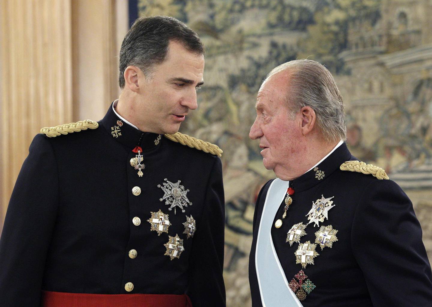(FILES) In this file photo taken on June 19, 2014 Spain's King Felipe (L) and his father Spain's former King Juan Carlos stand during a handing over ceremony for the sash of the Capitain General in the Chamber of Audiences at the Zarzuela Palace .  Spain's former king Juan Carlos, who is under investigation for corruption, has announced he plans to go into exile, the royal palace said on August 2, 2020.  / AFP / POOL / ZIPI
