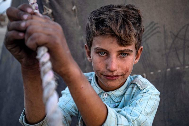 A Syrian boy at the Yunani camp for Syrians displaced by conflict in the countryside of Raqa, Hamah and other regions along the banks of the Euphrates river in Syria's northern province of Raqa. AFP