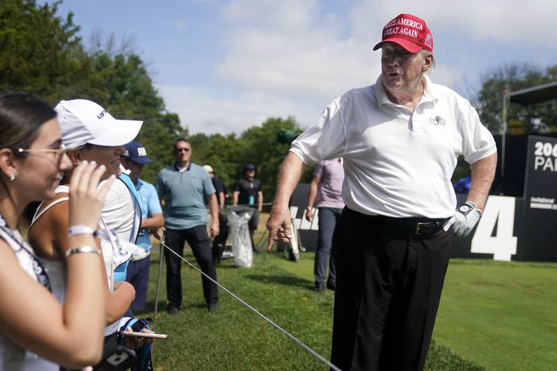 Mr Trump talks to golf fans. AP