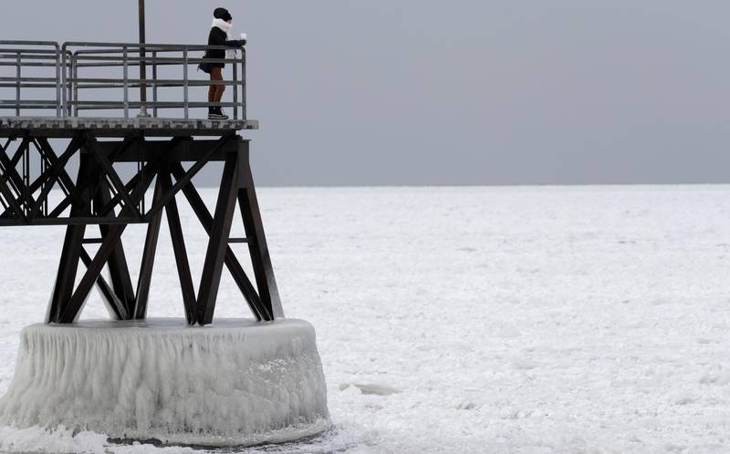 Michele King, 26, looks out over frozen Lake Erie, Wednesday, Jan. 3, 2018, in Cleveland. Dangerously cold temperatures have gripped wide swaths of the U.S. from Texas to New England. (AP Photo/Tony Dejak)
