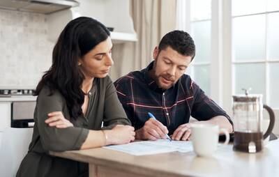 Shot of a young couple going over their finances together at home. Getty Images