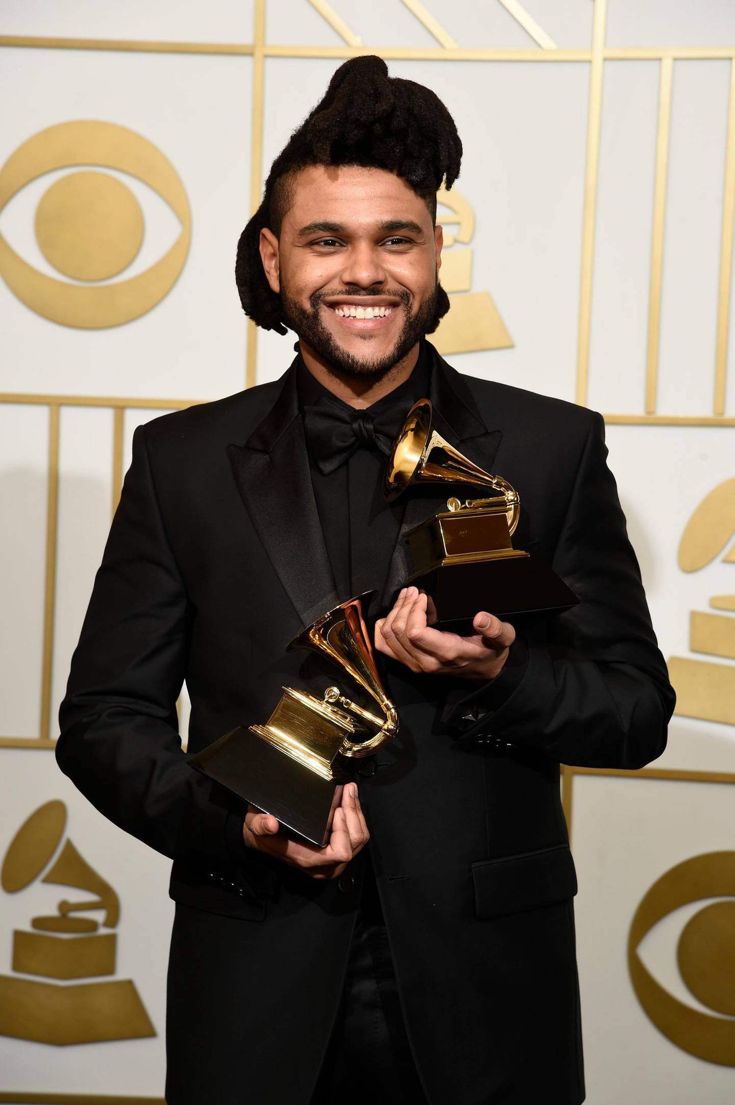 FILE - The Weeknd poses in the press room with the awards for best R&B performance for "Earned It (Fifty Shades of Grey)" and best urban contemporary album for "Beauty Behind The Madness" at the 58th annual Grammy Awards in Los Angeles on Feb. 15, 2016. The Grammy Awards are in discussion to remove its nomination review committees â€” the group that determines the contenders for key awards at the coveted music show. (Photo by Chris Pizzello/Invision/AP, File)