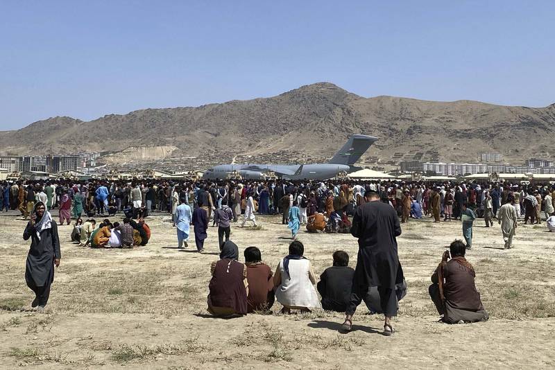 Hundreds gather near a US Air Force C-17 transport plane at the perimeter at the international airport in Kabul.  AP