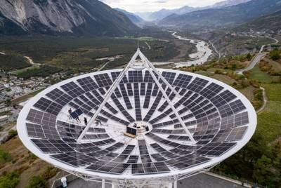 Employees install solar panels in a satellite dish at the Leuk Teleport and Data Centre in Leuk, Switzerland. Reuters
