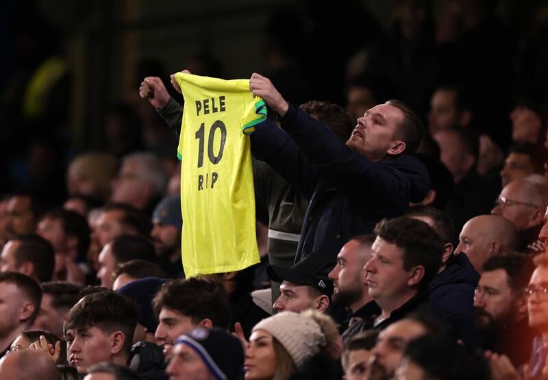 A fan holds up a Brazil shirt with 'Pele 10 RIP' written on it before the game. Getty