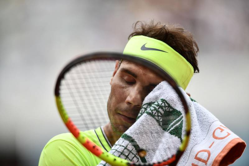 Nadal wipes his face with a towel. AFP