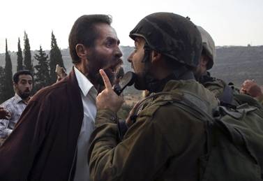 A Palestinian man argues with an Israeli soldier during clashes over an Israeli order to shut down a Palestinian school in the town of as-Sawiyah, south of Nablus in the occupied West Bank on October 15, 2018. AFP