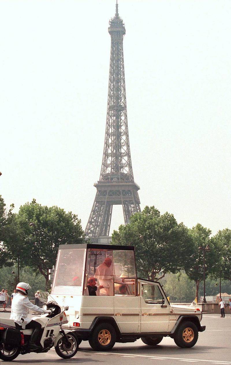 Pope John Paul II rides in his Popemobile in the streets of Paris near the Eiffel Tower, 21 August. The 77-year-old pontiff is on a four-day-visit to France to attend the 12th World Youth Days, an event which has rallied hundreds of thousands of young Catholics from 160 countries. (Photo by DIDIER PALLAGES / AFP)
